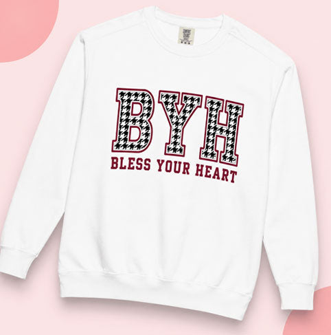 White crewneck sweatshirt featuring a black-and-white patterned “BYH” graphic with “Bless Your Heart” text in red.